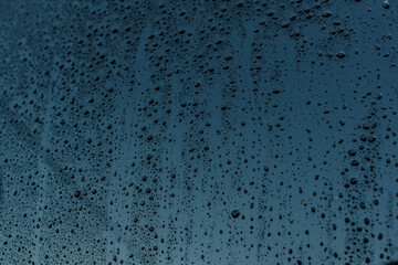 Texture of raindrops on the blue glass.