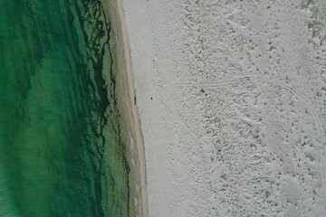 azure water and white foam from the waves on the coast of the island. top view