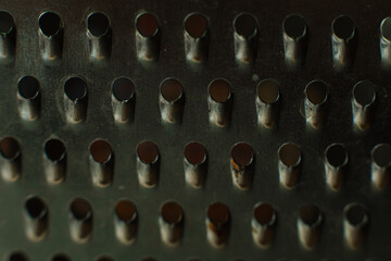 Economic device in the form of a metal plate with punctured small holes for grinding, rubbing something.