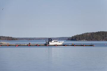 Mariefred, Sweden - April 20 2019: the view of Swedish landscape with boat by the pier, lake Malaren and forest on background on April 20 2019 in Mariefred, Sweden.