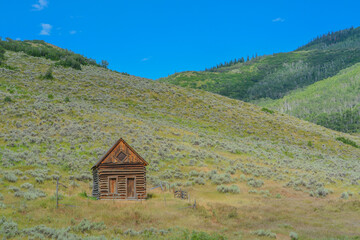Fototapeta na wymiar Old log cabin, abandoned in the country hillside of Rocky Mountains in Colorado