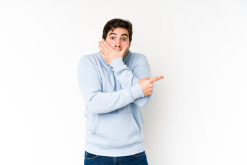 Young man isolated on white background pointing to the side