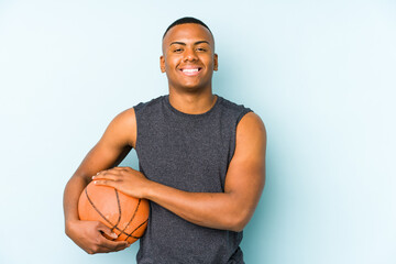 Obraz premium Young colombian man playing basketball isolated laughing and having fun.