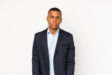 Young business latin man isolated on white background shrugs shoulders and open eyes confused.