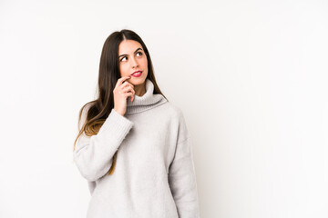 Young caucasian woman isolated on a white background looking sideways with doubtful and skeptical expression.