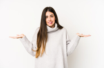 Young caucasian woman isolated on a white background confused and doubtful shrugging shoulders to...