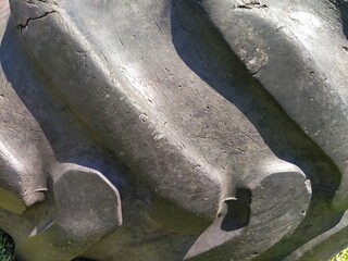 A tire from a tractor or truck wheel. Close-up of black rubber. Damage and cracks. The texture of...