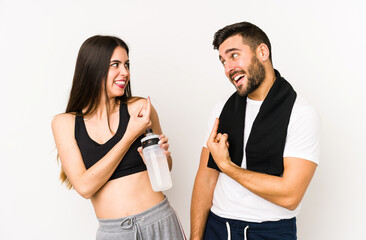 Young caucasian fitness couple isolated pointing with finger at you as if inviting come closer.