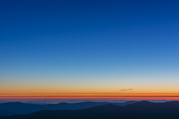 The first or last rays of the sun on a mountain pass. Morning and evening in nature. Colorful sunset and sunrise over the mountain hills. Carpathians in summer and autumn.