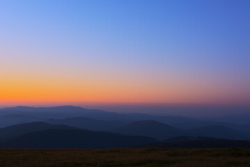The first or last rays of the sun on a mountain pass. Morning and evening in nature. Colorful sunset and sunrise over the mountain hills. Carpathians in summer and autumn.