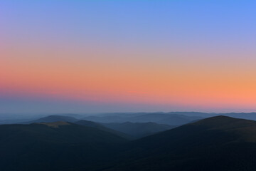 The first or last rays of the sun on a mountain pass. Morning and evening in nature. Colorful sunset and sunrise over the mountain hills. Carpathians in summer and autumn.