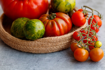 Basket with a variety of tomatoes, including: Cherry, Heirloom and Zebra