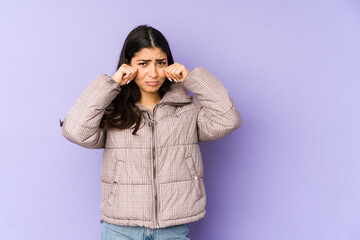 Young indian woman isolated on purple background whining and crying disconsolately.