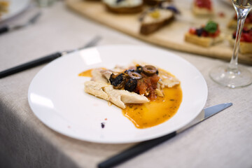 baked fish lies on a white plate,  dish in  restaurant