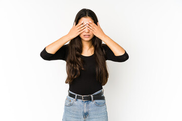 Young indian woman isolated on purple background afraid covering eyes with hands.