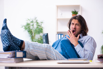 Male employee coming to work straight from bed