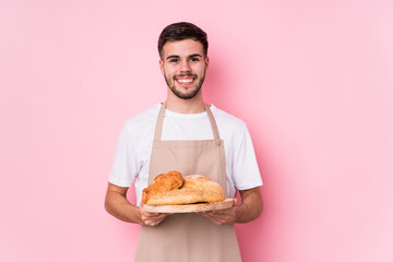 Young caucasian baker man isolated happy, smiling and cheerful.