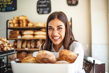 Woman holding fresh bread. Portrait of a confident woman working in a Bakery shop. I love my job!...