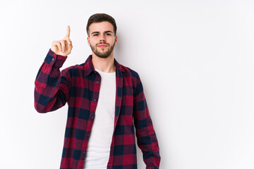 Young caucasian man posing in a white background isolated showing number one with finger.