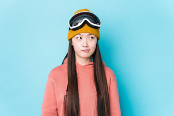 Young chinese woman wearing ski clothes isolated confused, feels doubtful and unsure.