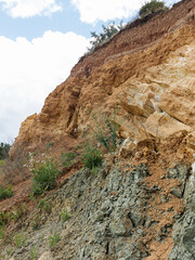 Mountain landslide disaster in sesmically dangerous area. Large cracks in earth, descent of large layers of earth blocking road. Mortal danger of damming people at foot of landslide slopes of mountain