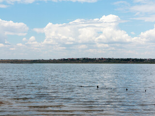 Salty estuary Kuyalnik, dead lake near Odessa, Ukraine. Wooden sticks reflected in blue water at sunny weather.