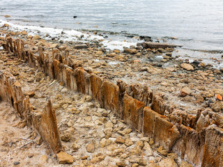 Salty estuary Kuyalnik, dead lake near Odessa, Ukraine. Wooden sticks reflected in blue water at sunny weather.