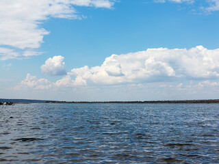 Salty estuary Kuyalnik, dead lake near Odessa, Ukraine. Wooden sticks reflected in blue water at sunny weather.