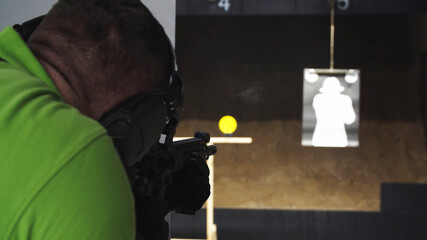 Adult loading an assault rifle at a shooting range