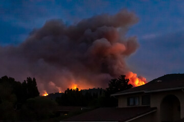 The California "River Fire" of Salinas,  in Monterey County, ignited by dry lightning on August 16, 2020, fills the evening sky with smoke and flames as it burns close to houses on its first day.  