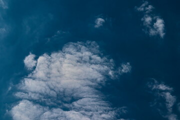 thin cirrocumulus clouds, floating under a blue sky covered by a very fine mist.