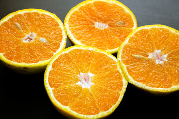 top view of 2  sliced oranges on  a black table. selective focus