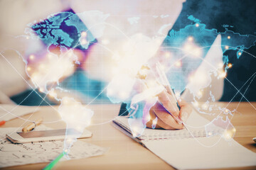 Double exposure of business theme drawing over people taking notes background. Concept of financial world