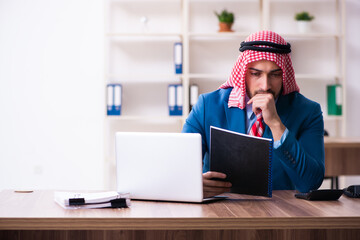 Young male arab employee working in office