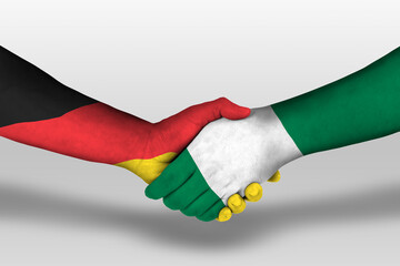 Handshake between nigeria and germany flags painted on hands, illustration with clipping path.