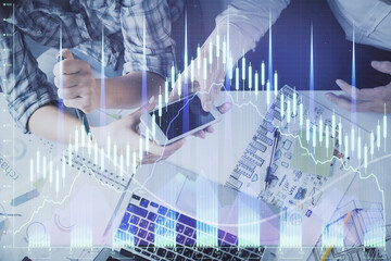 Double exposure of forex graph drawing and man and woman working together holding and using a mobile device. Trade concept.