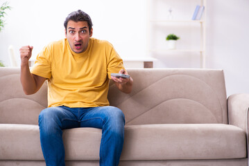 Young man watching tv at home