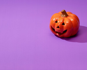 Pumpkin on a violet background, Halloween backdrop.