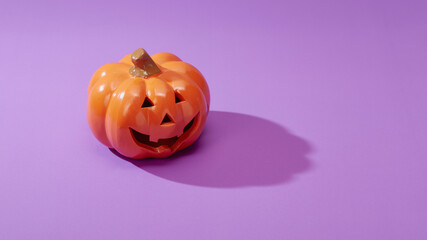 Pumpkin on a violet background, Halloween backdrop.