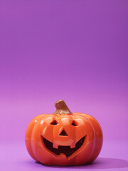 Pumpkin on a violet background, Halloween backdrop.
