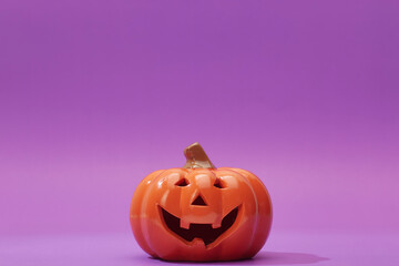 Pumpkin on a violet background, Halloween backdrop.