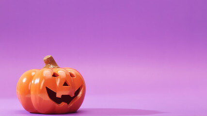 Pumpkin on a violet background, Halloween backdrop.