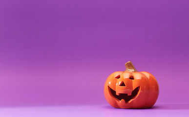 Pumpkin on a violet background, Halloween backdrop.