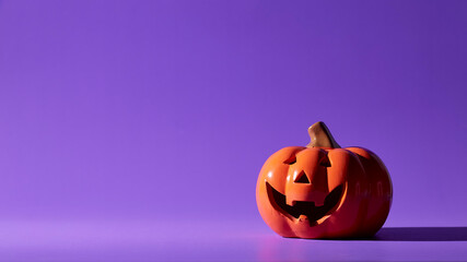 Pumpkin on a violet background, Halloween backdrop.