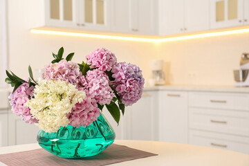 Bouquet of beautiful hydrangea flowers on table in kitchen, space for text. Interior design