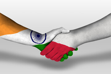 Handshake between poland and india flags painted on hands, illustration with clipping path.