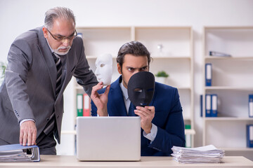 Old boss and young male employee wearing masks