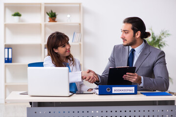 Obraz premium Young female doctor and sick businessman in the office