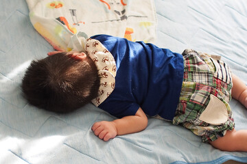 ベッドで寝ている日本人の赤ちゃん