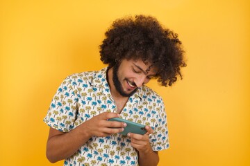 Close-up portrait of Young man with afro hair over wearing hawaiian shirt standing over yellow...